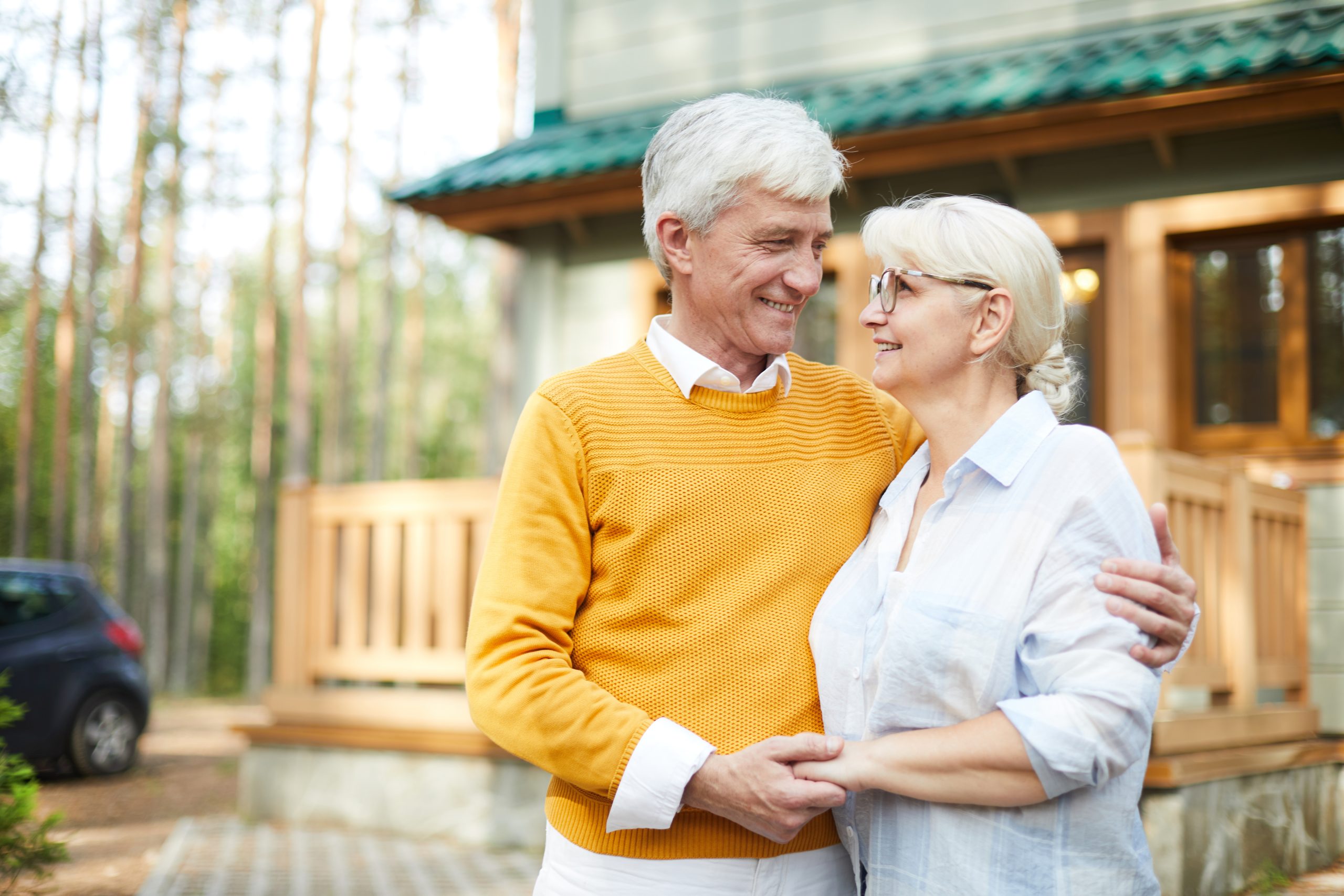 Elderly-couple-infront-of-their-home-scaled