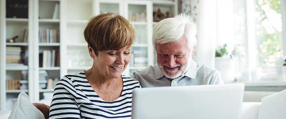 An older Canadian couple comparing different home equity loan and reverse mortgage options to help them out with their savings.