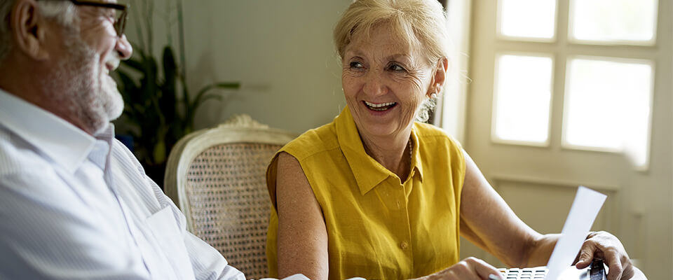 An older couple laughing and sitting together at a table