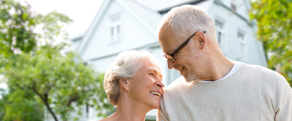 Canadian senior couple smiling and happy about retaining their home after taking a home equity loan.