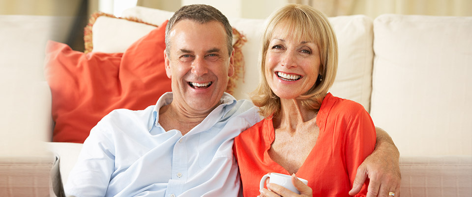 Senior couple relaxing in their living room, satisfied that they used the funds from their reverse mortgage in Canada fruitfully.